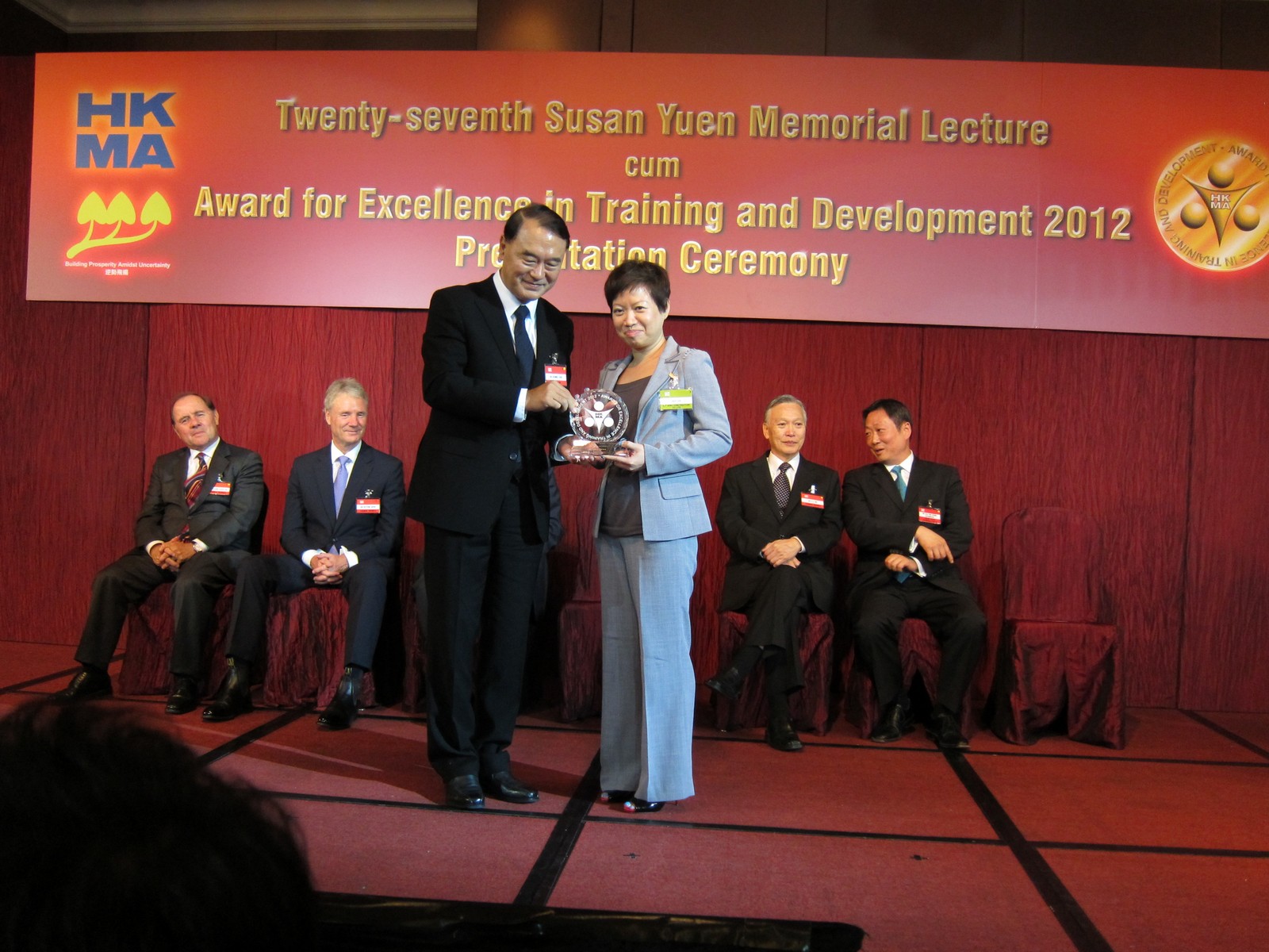 Dr Dennis Sun, BBS, JP, HKMA Chairman, presents the Silver Award in the Development Category of the HKMA's Awards for Excellence in Training and Development 2012 to Ms. Ada Lee, Manager (Training & Development) of Hip Hing Construction